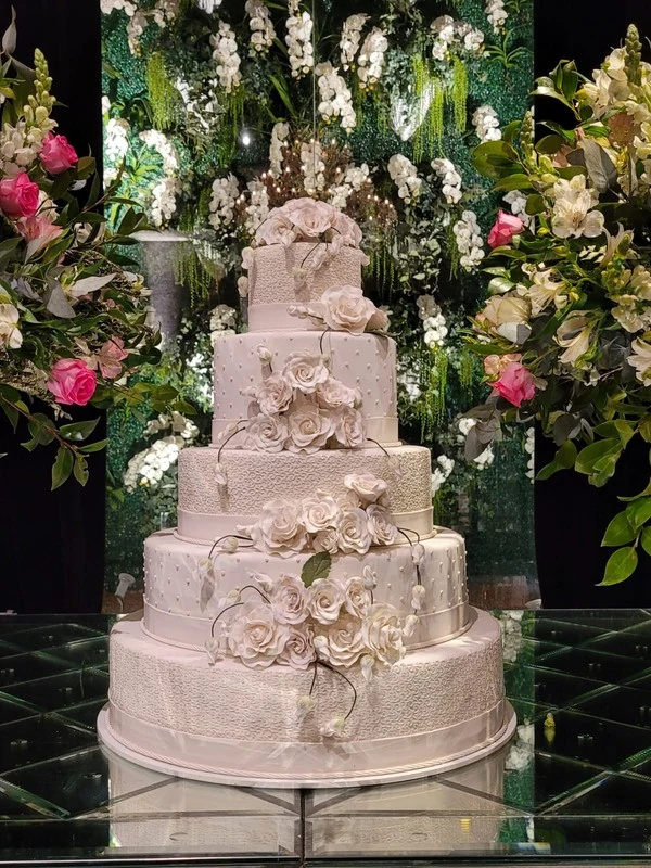 Bolo cenográfico de casamento em tons claros com flores e acabamento artesanal